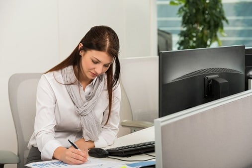 Businesswoman Writing At Desk